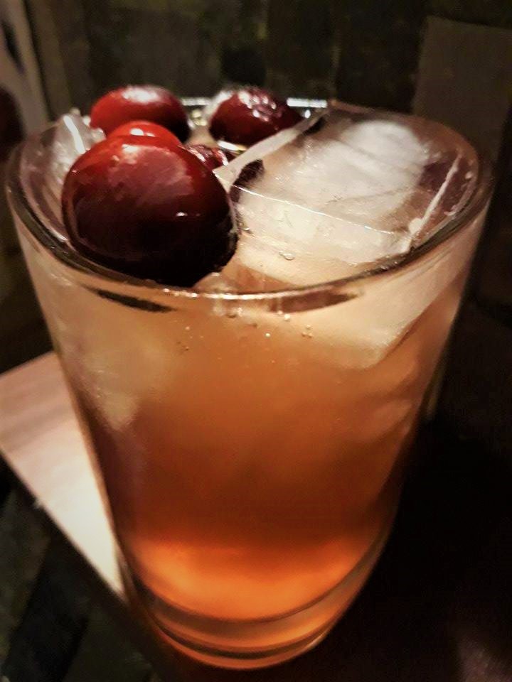 A cocktail with cherries and ice in a glass called Blizzard Cocktail.