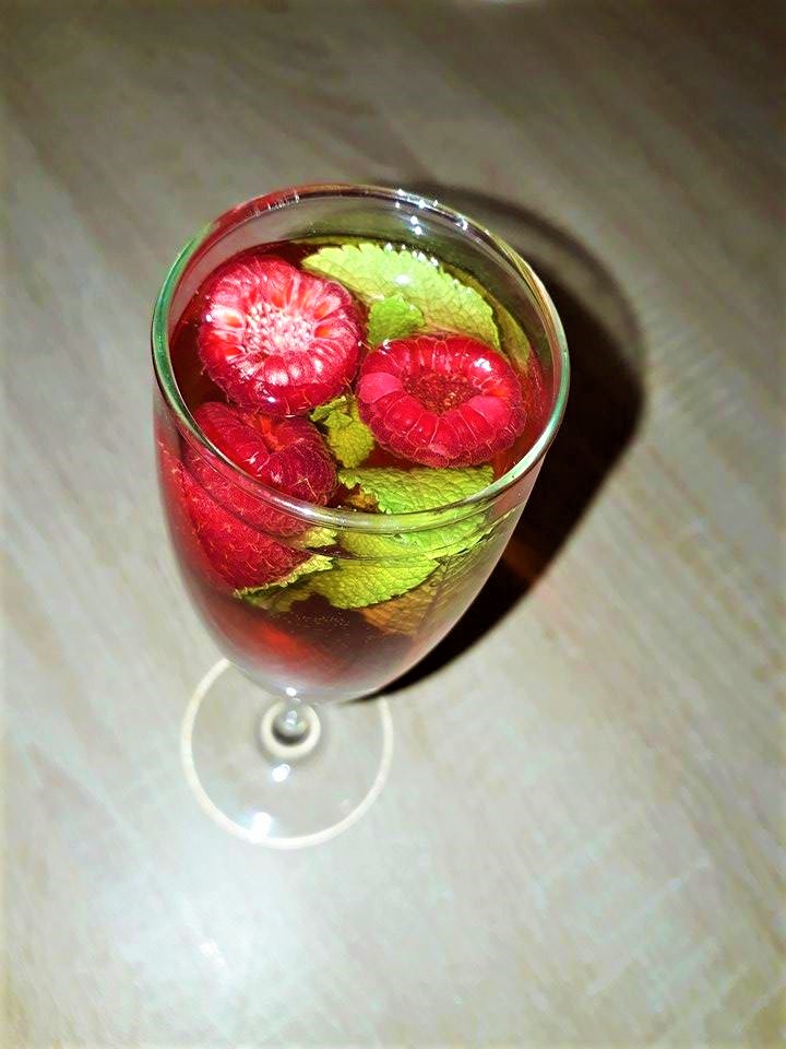 A glass filled with cranberries and mint.