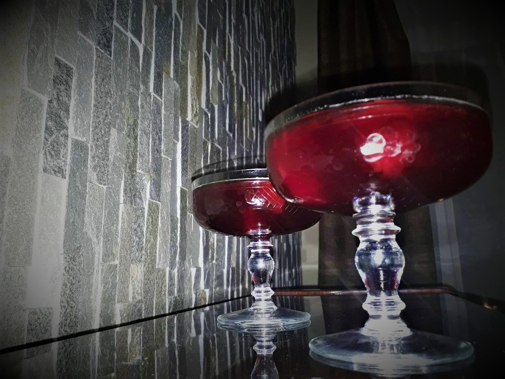 Two glasses of cherrytini sitting on top of a table, perfect for the holidays.