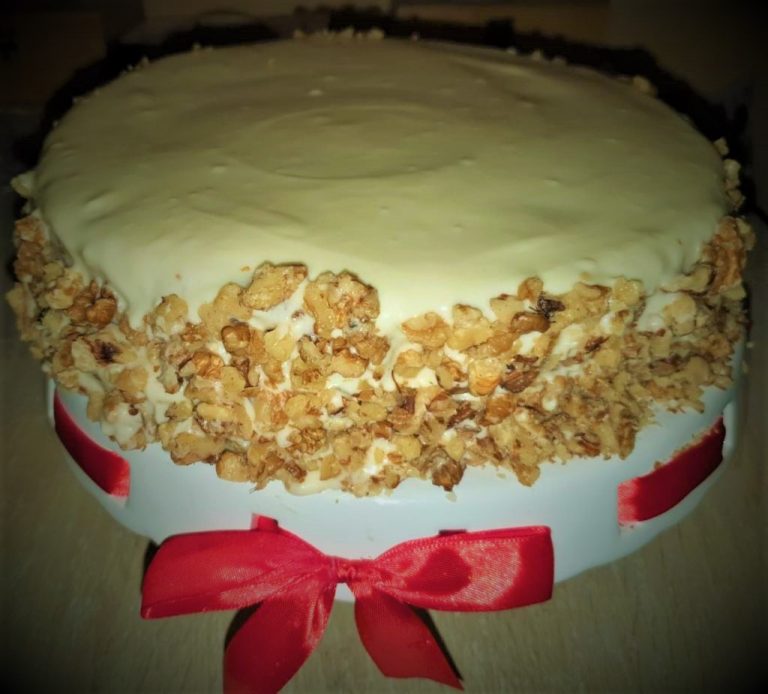 A white cake with a red ribbon on top.