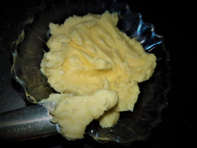Butter in a bowl with a knife in it.
